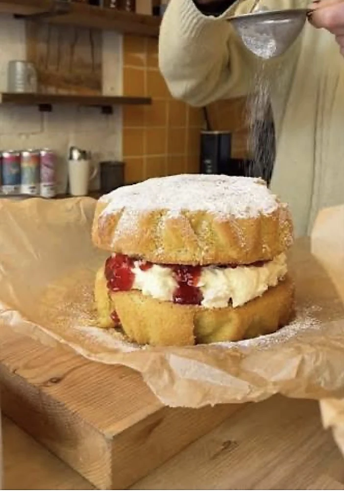 Victoria sponge being dusted with icing sugar at the Wardrobe